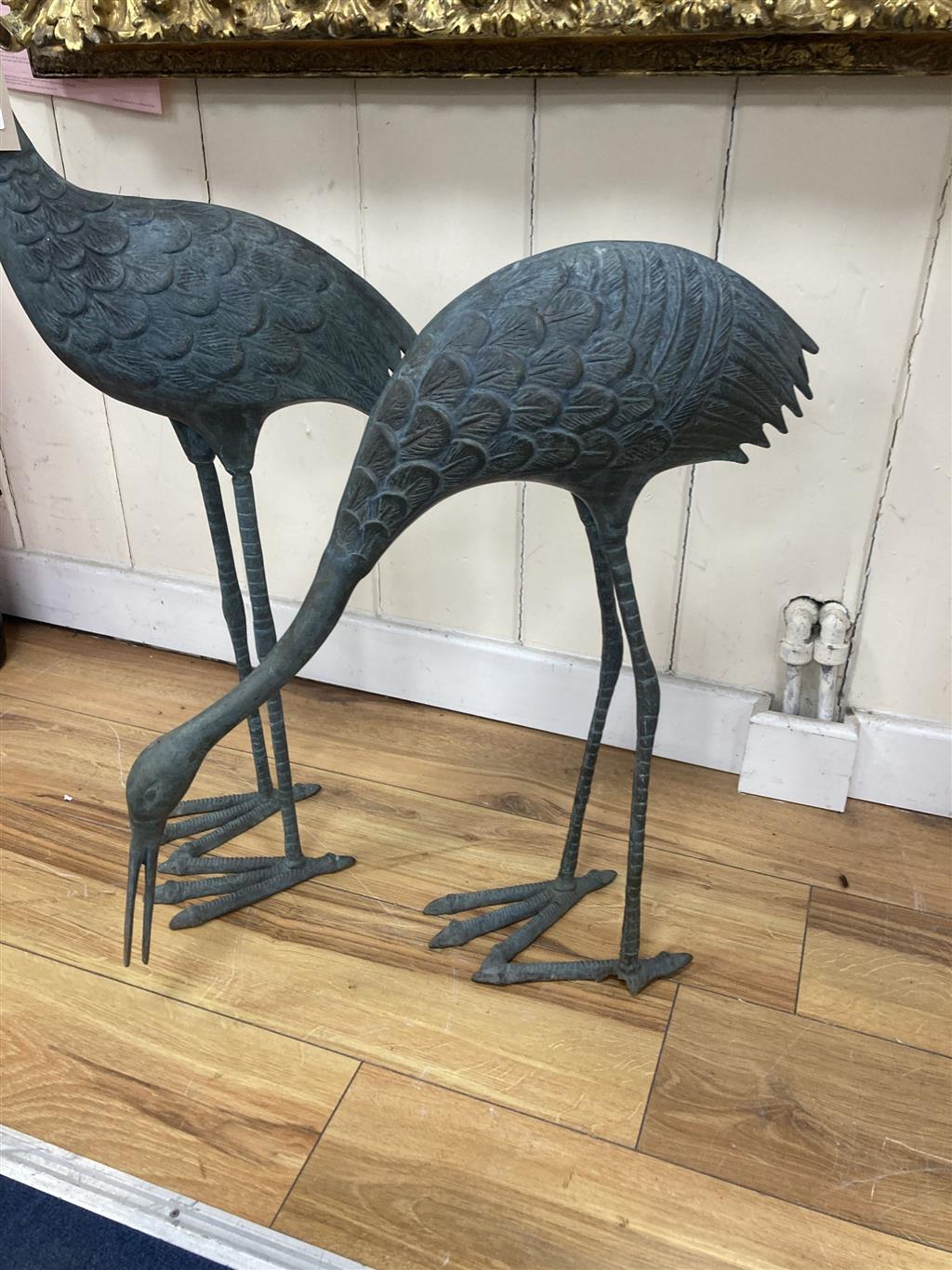 A pair of patinated bronze cranes, larger 89cm high